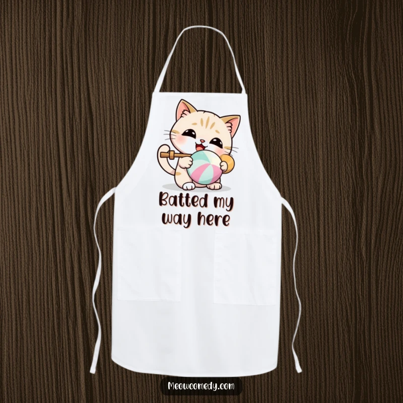 Funny apron depicting a kawaii cat joyfully batting a colorful ball, perfect for playful cooks.