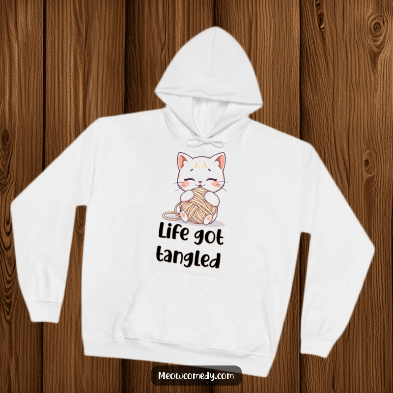 Funny kawaii cat comically tangled in a ball of yarn, a warm and humorous hoodie for relaxation.