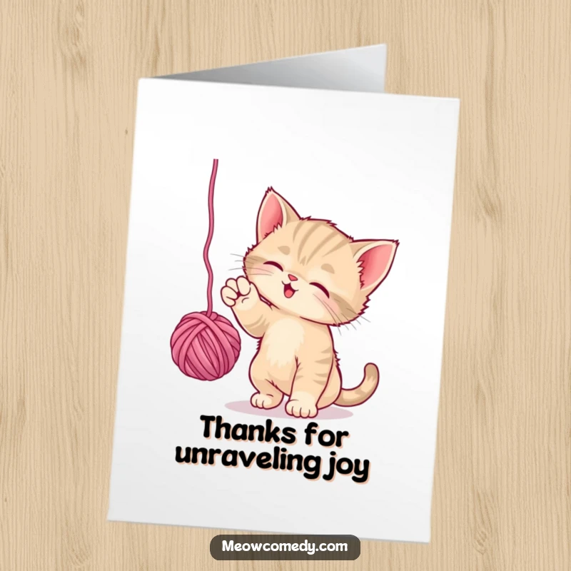 Funny free printable thank you card: a playful kitten batting enthusiastically at a dangling ball of yarn.